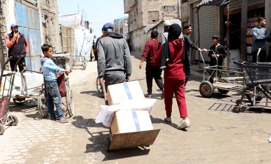 فلسطينيون يتلقون مساعدات غذائية من مركز توزيع للمواد الغذائيى تابع لبرنامج الأغذية العالمي.